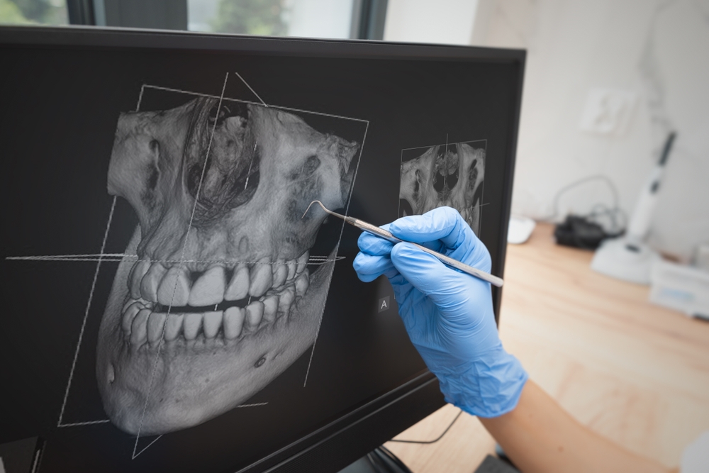 Dental consultation in clinic. Dentist showing teeth x-ray on digital tablet screen. 3D tomography technology.