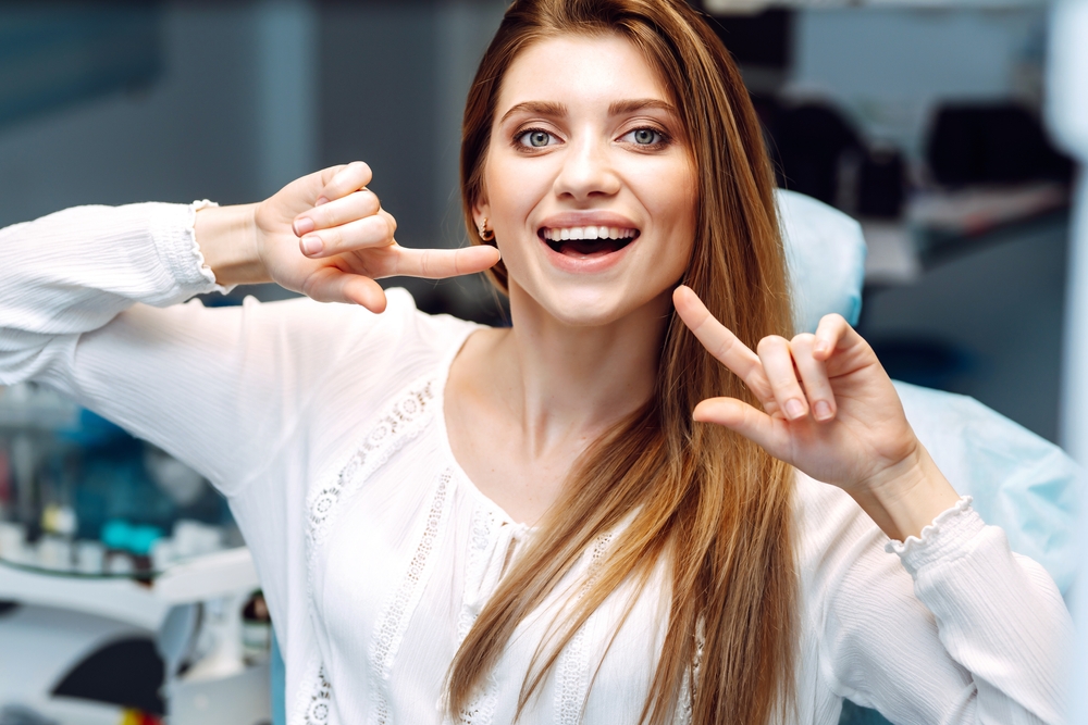 Woman pointing at her teeth - Dentures in Seattle